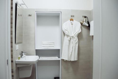 a bathroom with a white robe hanging on a wall at Residence Odesskij Dvorik in Odesa