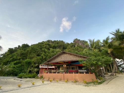 ein Haus am Strand mit einem Berg in der Unterkunft Borawan Island Resort by Cocotel in Quezon