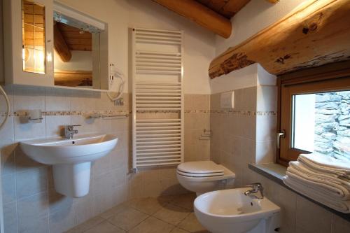 La salle de bains est pourvue d'un lavabo, de toilettes et d'une fenêtre. dans l'établissement Chambres d'Hotes Rue Saint Bernard, à Rhemes-Saint-Georges