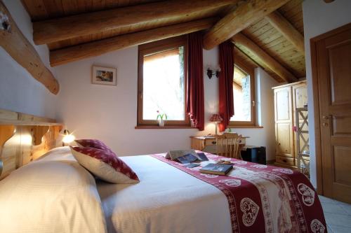 una camera con un grande letto in una stanza con soffitti in legno di Chambres d'Hotes Rue Saint Bernard a Rhemes-Saint-Georges