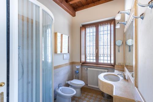 a bathroom with a sink and a toilet and a shower at Il Casale Lonato - by Host4U in Lonato del Garda