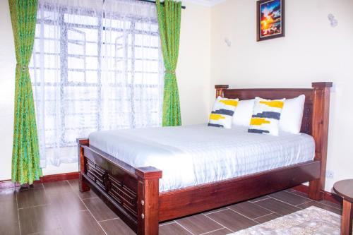 a bedroom with a bed and a large window at Kasty G Studio - W Place Apartments in Nairobi
