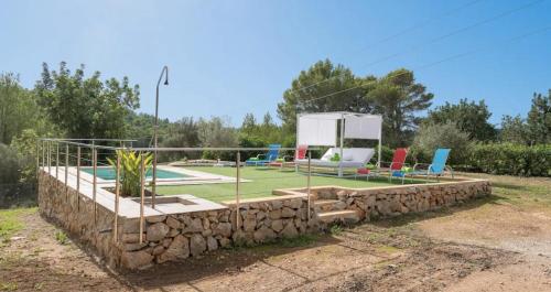 a stone retaining wall with colorful chairs on it at Villa Calvià countryside in Calvià