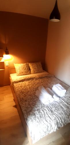 a bedroom with a bed with white sheets and pillows at OSADA POD LASEM in Andrychów