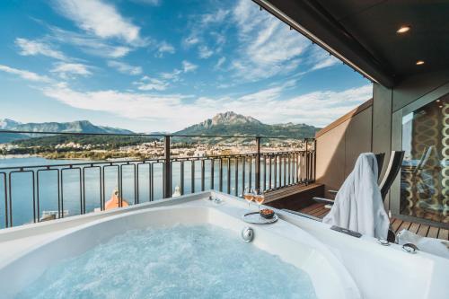 a bath tub on a balcony with a view of the water at Art Deco Hotel Montana Luzern in Luzern