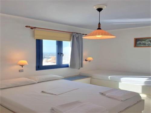 una camera con due letti e una finestra di Room in Apartment - Spacious Room in Creta for 3 people, with Ac, Swimming Pool and Nature a Hersonissos