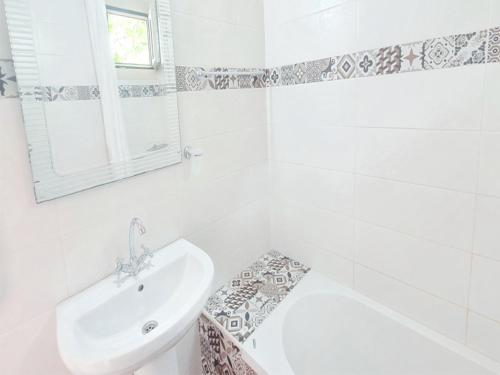 biała łazienka z umywalką, wanną i toaletą w obiekcie Room in Apartment - Spacious Room in Creta for 3 people, with Ac, Swimming Pool and Nature w mieście Hersonissos