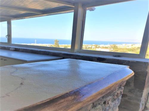 a table in a room with a view of the ocean at Spacious Room in Creta for 3 people, with Ac, Swimming Pool and Nature in Hersonissos