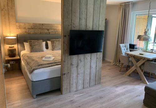 a bedroom with a bed and a tv on a wall at ferienapartment hahnenklee Apart.2 in Hahnenklee-Bockswiese