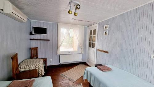 a white room with two beds and a window at Poilsio nameliai Pasartele in Kavoliai