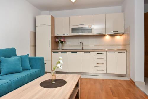 a living room with a blue couch and a table at APARTMANI PETRA in Vir