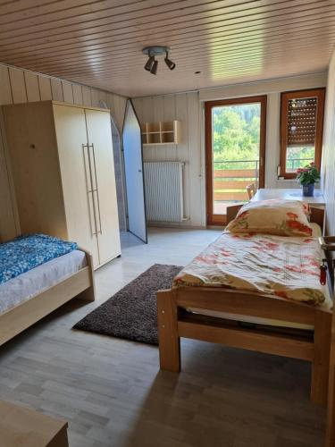 a bedroom with two beds and a refrigerator at Pension Zollern in Bisingen