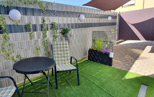 a patio with a table and chairs on the grass at Studio Appartement in Speichersdorf