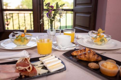 a table with plates of food and glasses of orange juice at RVHotels Palau Lo Mirador in Torroella de Montgrí