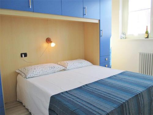a bedroom with a large bed with blue cabinets at Gardenia Apartment Ossuccio in Ossuccio