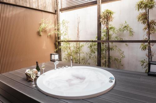ein Badezimmer mit einem großen weißen Waschbecken auf einem Holztisch in der Unterkunft Shiki Suites - Kyoto Umekoji in Kyoto