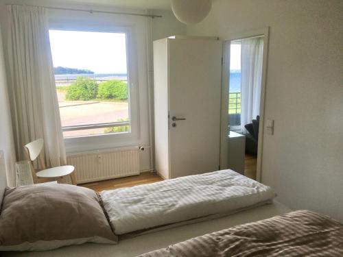 ein Schlafzimmer mit einem Bett und einem großen Fenster in der Unterkunft Seaside in Glücksburg