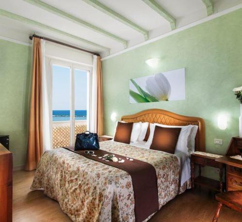 um quarto com uma cama e vista para o oceano em Hotel Internazionale em Cesenatico