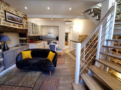 a living room with a couch and a kitchen at Casa Anca Deluxe in Sarlat-la-Canéda