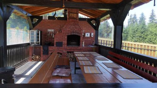 a room with wooden tables and a brick fireplace at Aqualina Colibita in Colibiţa