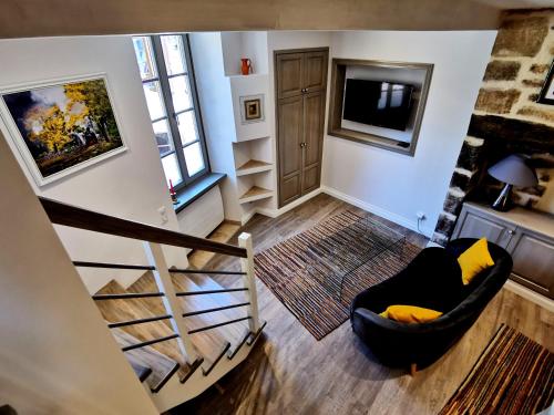 a living room with a staircase and a chair at Casa Anca Deluxe in Sarlat-la-Canéda