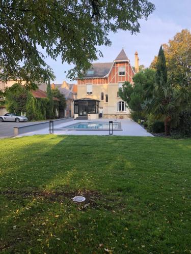 a large house with a swimming pool in the yard at Le Pavillon de Nathalie in Isles-sur-Suippe