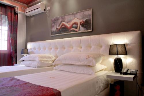 a bedroom with a white bed with a white headboard at Hotel Boutique Vila Fernando Tirana in Tirana