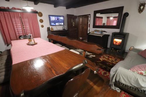 a dining room with a wooden table and a couch at Villa Pepeljuga kuća za odmor in Vižovlje