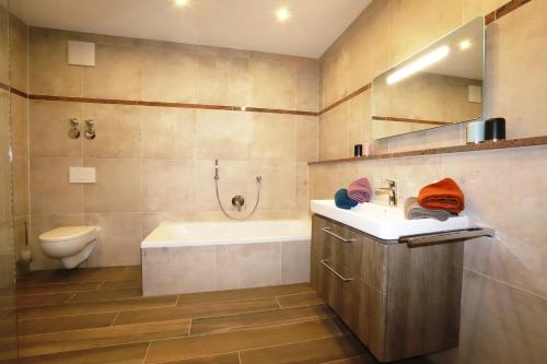 a bathroom with a tub and a sink and a toilet at Ferienwohnungen Josef Koll in Marktschellenberg