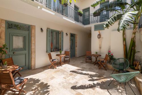 a patio with chairs and tables and a balcony at Casa Natura in Rhodes Town