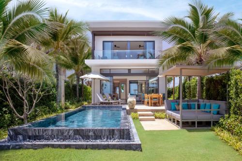 una villa con piscina e una casa di Melia Ho Tram Beach Resort a Ho Tram