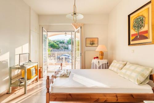 a bedroom with a large bed and a balcony at Casa Nebari Seaside Retreats - Fully Equipped, Ideal Spot in Petalidhion