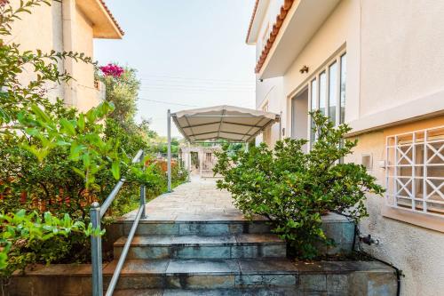 an umbrella on the stairs of a building at Casa Nebari Seaside Retreats - Fully Equipped, Ideal Spot in Petalidhion