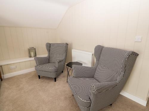 two chairs sitting next to each other in a room at Sgubor in Holyhead