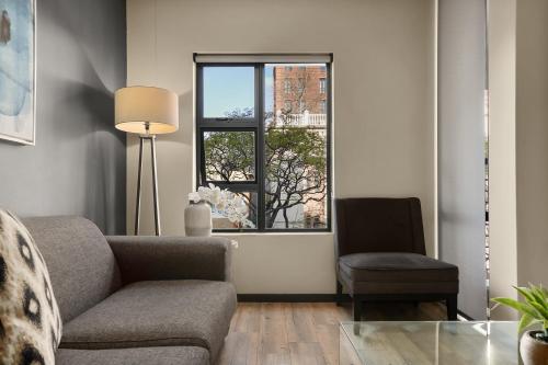 a living room with a couch and a window at Easy Stay - The Vantage Rosebank in Johannesburg