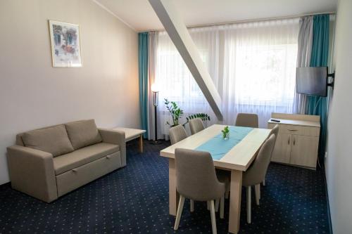 a room with a table and a couch and a chair at Zacisze Natura Tour in Spała