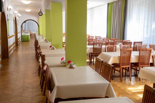 a dining room with tables and chairs and green walls at Zacisze Natura Tour in Spała
