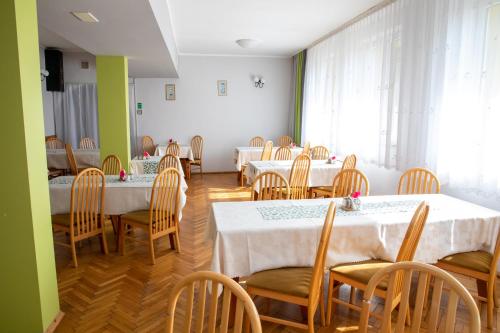 a dining room with tables and chairs and a room with green walls at Zacisze Natura Tour in Spała