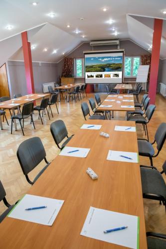 a conference room with tables and chairs and a projection screen at Zacisze Natura Tour in Spała
