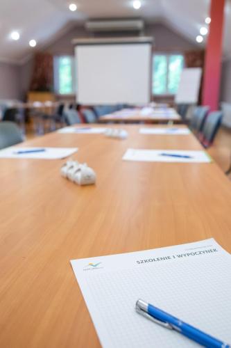 a long wooden table with pens and papers on it at Zacisze Natura Tour in Spała