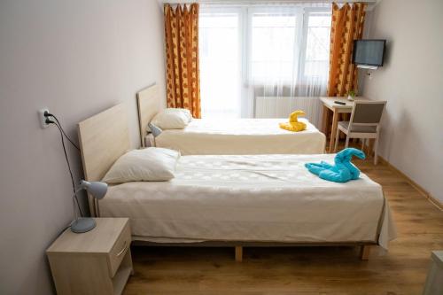 two beds in a bedroom with a blue toy duck on them at Zacisze Natura Tour in Spała