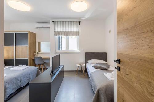 - une chambre avec 2 lits, un bureau et une table dans l'établissement Luxury Villa Lara with a pool, à Milna