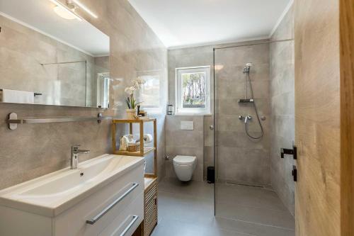 une salle de bain avec douche, lavabo et toilettes dans l'établissement Luxury Villa Lara with a pool, à Milna