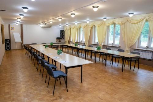 a row of tables and chairs in a room with windows at Zacisze Natura Tour in Spała