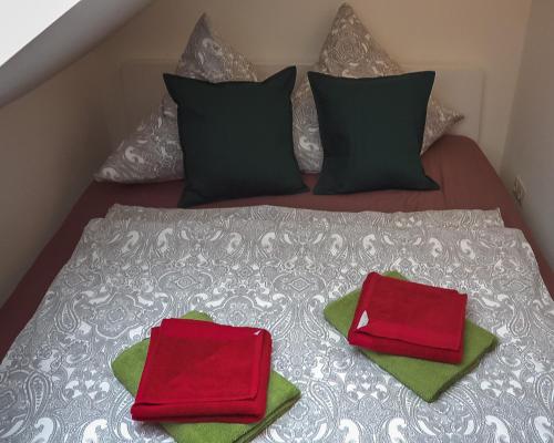 two red pillows sitting on top of a bed at Appartementhaus- Bredner / Appartement IV in Rathmannsdorf