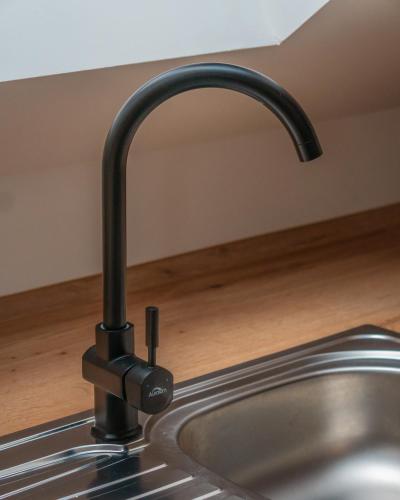 a kitchen sink with a black kitchen faucet at Appartementhaus- Bredner / Appartement IV in Rathmannsdorf