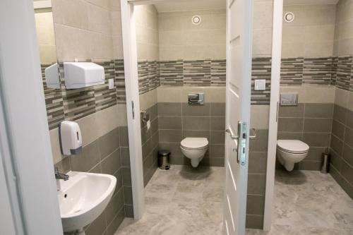 a bathroom with two toilets and a sink at Zacisze Natura Tour in Spała