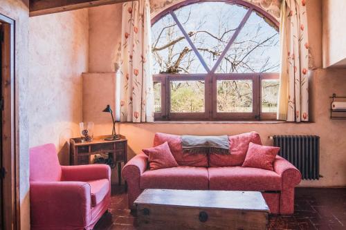 a living room with a pink couch and a window at Mas Teixidor in Crespiá