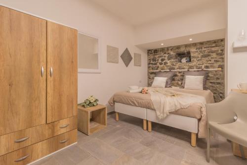 sypialnia z łóżkiem i kamienną ścianą w obiekcie Casa Camelia Varenna w mieście Varenna