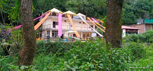 una casa pintada de rosa y naranja en Hideout, en Bīr